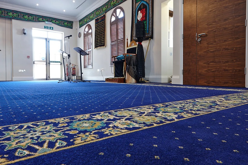 How do mosque carpets emphasize the architecture of the mosque?